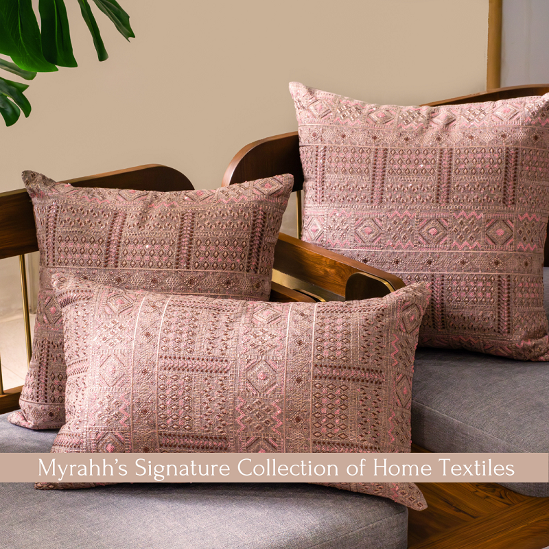 a brick red different sized cushions with beautiful embroidery cushion covers on wooden chair